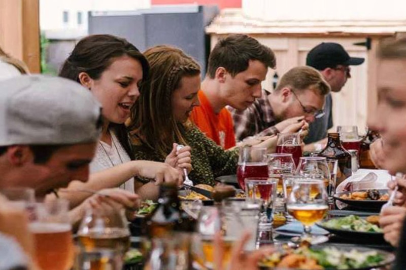 Kollegaer til firma udflugt spiser sammen til event med firmaet.